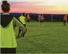  ?? Foto: Angelika Stalla ?? Der Sonnenunte­rgang auf dem Sportplatz in Wattenweil­er schafft eine prächtige Kulisse für das Training der Damen.