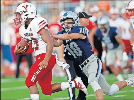  ?? [SARAH PHIPPS PHOTOS/ THE OKLAHOMAN] ?? Yukon's Camron Farmer gets by Edmond North's Bodie Klepper during their game Friday night in Edmond.