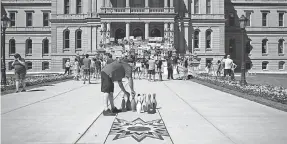  ?? USA TODAY NETWORK ?? A man sets up a makeshift lane at a rally at the Michigan Capitol demanding that the government let bowling centers reopen last August.