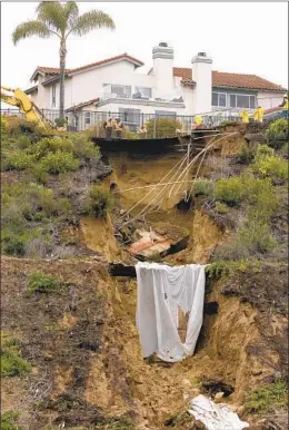  ?? HAYNE PALMOUR IV FOR THE U-T ?? Runoff that caused a large sinkhole from recent rains flows down a ravine at the south end of Lake Drive in Cardiff as repair work continues Saturday.