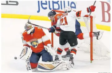  ?? JOE SKIPPER/AP ?? Florida Panthers defenseman Aaron Ekblad (5) and New Jersey Devils right wing Kyle Palmieri (21) collide with the goal behind Panthers goaltender Roberto Luongo (1) during the first period on Thursday.