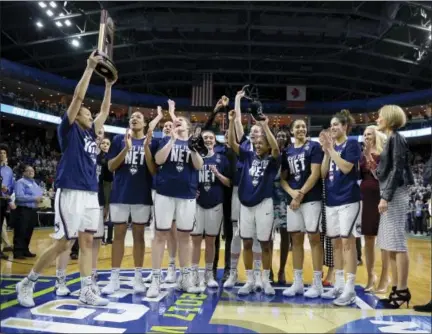  ?? JESSICA HILL — THE ASSOCIATED PRESS ?? UConn’s Saniya Chong holds the trophy as her teammates cheer following their 90-52 win over Oregon in the NCAA Tournament regional final in Bridgeport on Monday.