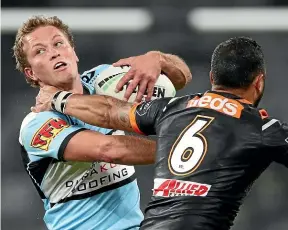  ?? GETTY IMAGES ?? Sharks back Matt Moylan gets scragged by the Wests Tigers defence at Bankwest Stadium in Sydney last night.