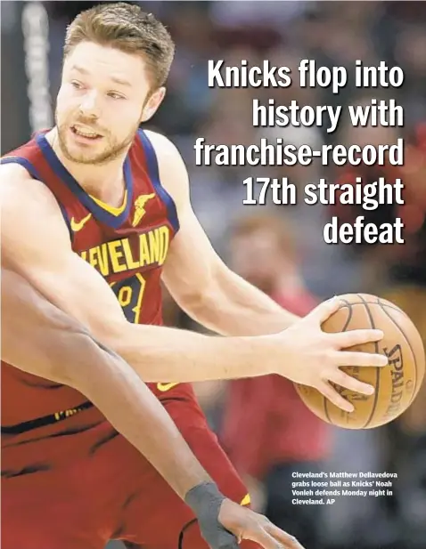  ??  ?? Cleveland’s Matthew Dellavedov­a grabs loose ball as Knicks’ Noah Vonleh defends Monday night in Cleveland. AP