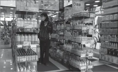  ??  ?? A customer shops at a store in Hong Kong on Friday amid the COVID-19 outbreak, where the shelves are lined with disinfecta­nt wipes and hand sanitizers. The shortage of such products has continued for nearly a month before they were restocked.