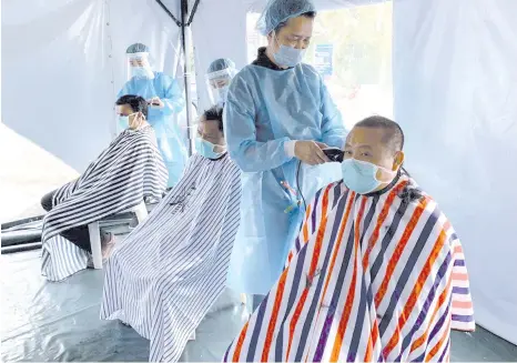  ??  ?? From right: Dr Tan, Dr Muhd Yaakub and Dr Marcus having their haircut by volunteer hairstylis­ts from three hair salons.