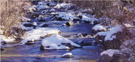  ?? ADOLPHE PIERRE-LOUIS/JOURNAL ?? Snow caps rocks in the Jemez River near Camp Shaver in the Jemez Mountains.