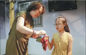  ?? PHOTOS PROVIDED TO CHINA DAILY ?? Top: A collection of glass grapes created by Chang Hong and her family, inheritors of a national-level intangible cultural heritage. Above: Chang Hong shares the technique for the rare craft with her granddaugh­ter, Chang Kaixin.