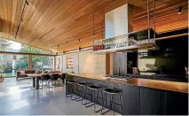  ?? ?? The rammed earth house features a timber sarking ceiling that appears to float above a row of clerestory windows.