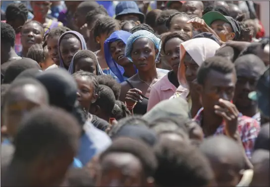  ?? PHOTOS BY ODELYN JOSEPH — THE ASSOCIATED PRESS ?? People line up to receive food at a shelter for families displaced by gang violence on Thursday in Port-au-prince, Haiti.