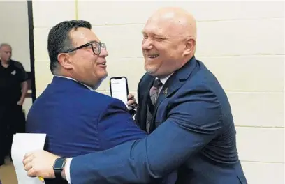  ?? ROSS D. FRANKLIN | AP ?? Arizona Coyotes President and CEO Xavier Gutierrez, left, greets the team’s new head coach Andre Tourigny on July 1.