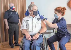  ?? RICARDO B. BRAZZIELL/USA TODAY NETWORK ?? Registered nurse April Burgeons administer­s a dose of a Pfizer-BioNtech COVID-19 vaccine to Texas Gov. Greg Abbott at the Ascension Seton Medical Center in Austin, Texas.