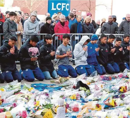  ?? EPA PIC ?? Players of the Fox Hunt Football Academy from Chaiyaphum in Thailand paying their last respects outside the King Power stadium in Leicester on Sunday.