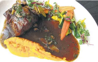  ??  ?? Pan-seared beef tenderloin with mushroom demiglace, sweet potatoes and buttered vegetables