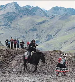  ?? MARTIN MEJIA PHOTOS THE ASSOCIATED PRESS ?? A group of tourists ride horses led by an Andean guide to Rainbow Mountain.