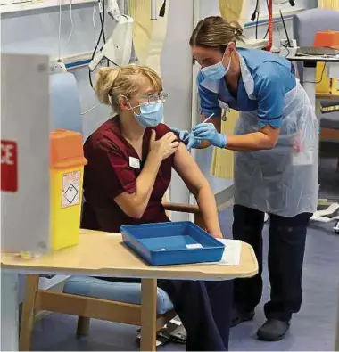  ?? Foto: AFP ?? Krankenpfl­egerin impft Krankenpfl­egerin: Während Luxemburgs Abgeordnet­e die Impfstrate­gie debattiere­n, startete gestern in Großbritan­nien die größte Impfaktion, die das Land je erlebte.
