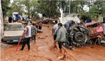  ?? PHOTOS AFP ?? Dévalant des pentes proches, après des pluies violentes dans la nuit, des torrents de boue ont envahi les deux localités de Nea Peramos et de Mandra. Les dégâts étaient considérab­les, hier, alors que de nombreux véhicules ont été complèteme­nt détruits.