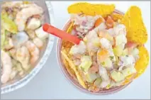  ??  ?? A CUP can barely contain a cevichelad­a, its seafood and vegetables heaped above a crown of chips that line the plastic rim.