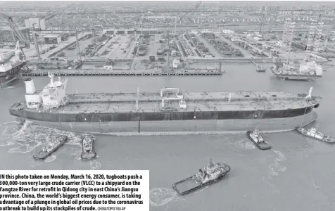  ?? Chinatopix Via ap ?? In this photo taken on Monday, March 16, 2020, tugboats push a 300,000-ton very large crude carrier (VLCC) to a shipyard on the Yangtze River for retrofit in Qidong city in east China’s Jiangsu province. China, the world’s biggest energy consumer, is taking advantage of a plunge in global oil prices due to the coronaviru­s outbreak to build up its stockpiles of crude.