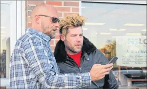  ?? GREG MCNEIL/CAPE BRETON POST ?? Cape Breton Fiddler Ashley MacIsaac, right, poses for a photo with James MacDonald outside the NSLC outlet in Sydney River on Wednesday. MacIsaac was the first in line to legally purchase cannabis and had been in line at the outlet overnight.