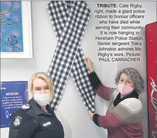  ??  ?? TRIBUTE: Cate Rigby, right, made a giant police ribbon to honour officers who have died while serving their community. It is now hanging in Horsham Police Station. Senior sergeant Tracy Johnston admires Ms Rigby’s work. Picture: PAUL CARRACHER