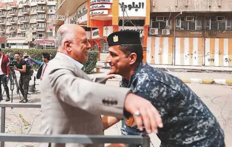  ?? AFP ?? Prime Minister Haider Al Abadi being searched by a member of the federal police upon arriving at a poll station in the capital Baghdad’s Karrada district, as the country votes in the first parliament­ary election since declaring victory over Daesh.