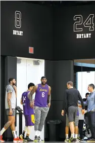  ?? MARK J. TERRILL — THE ASSOCIATED PRESS ?? The Lakers’ Anthony Davis, left, stands with LeBron James as Kobe Bryant’s numbers are displayed at the team’s practice facility on Wednesday in El Segundo, Calif.