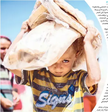  ??  ?? طفل سوري نازح يحمل خبزًا في مخيم مؤقت لالجئين في قرية عين عيسى أمس. (أ. ف. ب)