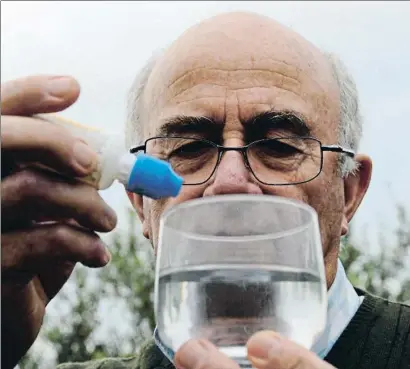  ?? MERCÈ GILI ?? Josep Pàmies, ayer en su finca de plantas medicinale­s de Balaguer, con un frasco de clorito de sodio