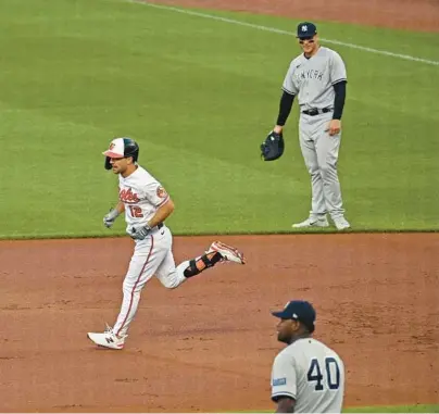  ?? KENNETH K. LAM/BALTIMORE SUN ?? The Orioles’ Adam Frazier, left, runs the bases past Yankees first baseman Anthony Rizzo, top right, after hitting a three-run home run off pitcher Luis Severino, bottom right, in the first inning Sunday night.
ORIOLES 9, YANKEES 3