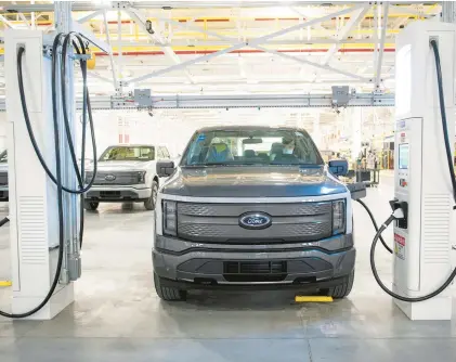  ?? DAVID GURALNICK/TRIBUNE NEWS SERVICE ?? An electric pickup truck charges at charging station in Dearborn, Michigan. Columnist Anthony O’Brien says President Joe Biden’s approach to electric vehicles is among the ways he’s making a mess of climate policy.