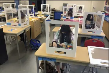  ?? ASSOCIATED PRESS FILE PHOTO ?? Socially distanced, and with protective partitions, students work on an art project during class at the Sinaloa Middle School in Novato, Calif.