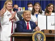  ?? BRANDON / ASSOCIATED PRESS
ALEX ?? President Donald Trump holds up a signed executive order on lowering drug prices in the South Court Auditorium in the White House complex Friday.