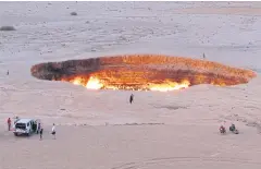  ?? AFP ?? Tourists visit the ‘Gateway to Hell’, a huge burning gas crater in the heart of Turkmenist­an’s Karakum desert.