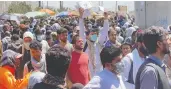  ?? REUTERS / STRINGER ?? Crowds of people show their documents to U.S. troops
outside the airport in Kabul on Thursday.