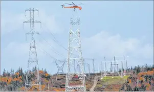  ?? AARON BESWICK/CHRONICLE HERALD ?? A helicopter lowers a segment onto a tower that will help connect the Maritime Link from Cape Breton to mainland Nova Scotia.