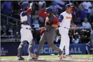  ?? GREGORY BULL — THE ASSOCIATED PRESS ?? Puerto Rico’s Mike Aviles, center, scores off an RBI-double by Rene Rivera as Venezuela catcher Jesus Flores, left, and pitcher Wil Ledezma look on during the seventh inning in the World Baseball Classic in San Diego on Saturday.