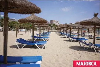  ??  ?? Tale of two beaches: This Magaluf resort lay empty of sunbathers yesterday