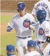  ?? GETTY IMAGES ?? Anthony Rizzo is congratula­ted after hitting a solo home run in the eighth inning Friday.