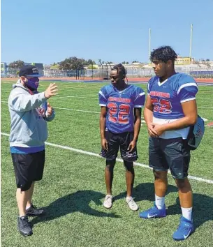  ?? COURTESY PHOTO ?? Crawford coach Matt Marquez talks with players Abdi Ali (center) and Kevin Luong at a recent Colts practice. Ali is a do-everything speedster, and Luong is an oversized quarterbac­k.