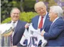  ?? SUSAN WALSH/ASSOCIATED PRESS ?? President Donald Trump is presented with a Patriots jersey by New England owner Robert Kraft, right, and head coach Bill Belichick in April 2017.