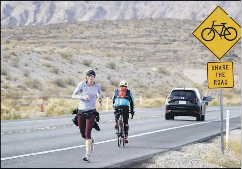  ?? PHOTOS BY STEVE MARCUS ?? A jogger, cyclist and car share the road Jan. 23 on State Route 159 near the Red Rock Canyon National Conservati­on Area. In the aftermath of the Dec. 10 tragedy near Searchligh­t in which five bicyclists were killed when they were hit by a box truck, safety efforts aimed toward sharing the road have been amplified in Southern Nevada.