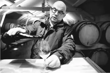  ??  ?? Rodez pours some of his vintage champagne in a glass in the vat room, of his champagne house in Ambonnay.