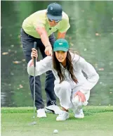  ?? — AFP ?? Rickie Fowler of the United States lines up a putt with girlfriend Allison Stokke during the Par 3 Contest prior to the start of the Masters.