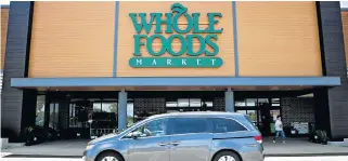  ?? /Bloomberg ?? Price war: A car passes in front of a Whole Foods Market store in Illinois, US. Amazon now has control of more than 460 of the group’s stores.