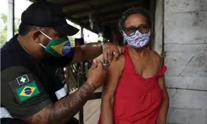  ??  ?? A health worker administer­s a Covid-19 vaccine in Brazil. Photograph: Bruno Kelly/Reuters