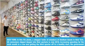  ??  ?? NEW YORK: In this file photo, a shopper looks at sneakers at Stadium Goods in New York. US consumers dipped deeper into their pockets in July 2018, increasing spending for the sixth month in a row and getting the third quarter off to a healthy start, the government reported yesterday. — AFP