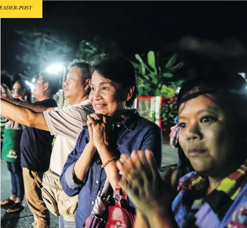  ?? LAUREN DECICCA / GETTY IMAGES ?? Onlookers watch and cheer as ambulances deliver boys rescued from a cave in northern Thailand to hospital in Chiang Rai after they were transporte­d by helicopter­s on Sunday. Divers began an effort to pull the 12 boys and their soccer coach out of the...