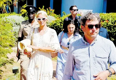  ?? HERBERT MCKENIS PHOTO BY ?? Paris Hilton, United States media personalit­y and children’s advocate, is escorted by Jason Henzell, chairman of Jakes Hotel, where she along with advocate attorneys spoke to the media expressing frustratio­n at how eight American boys were allegedly abused at a home in St Elizabeth by American caregivers.