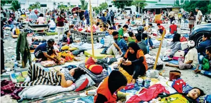  ?? AFP ?? Medical team members help patients outside a hospital after an earthquake and a tsunami hit Palu on Sulawesi island on Saturday. —